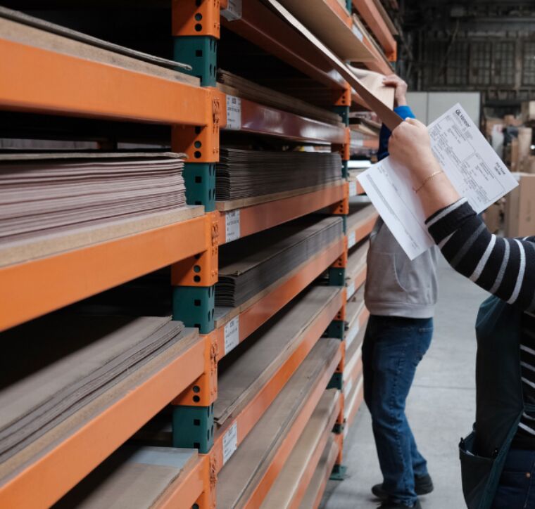 someone is picking a sheet of wood veneer from the