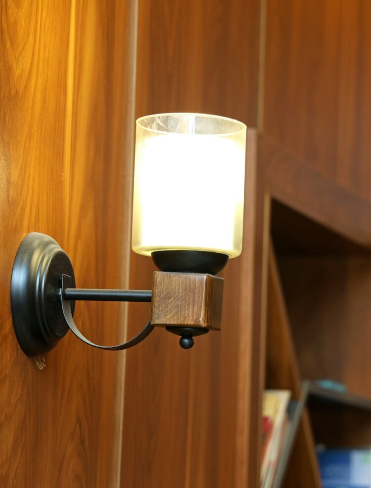 Warm-toned wood paneled wall with a sconce Warm-toned wood paneled wall with a sconce